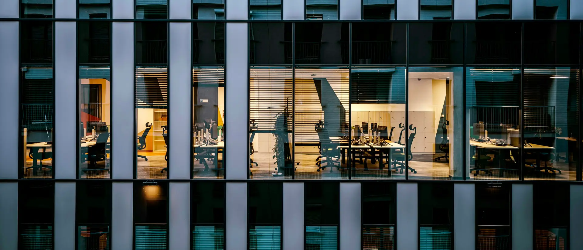 Modern office building facade with one floor lit at dusk